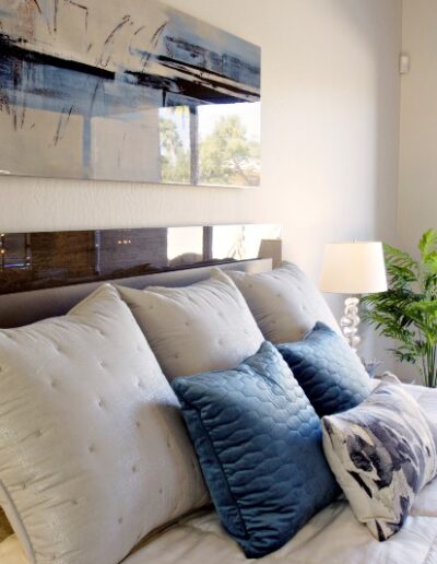 bed with white and blue pillows by Campos Interiors